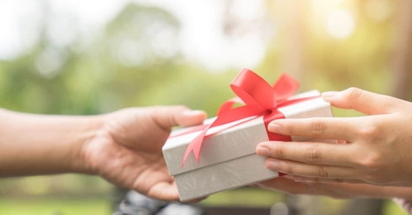 a person giving a gift to another person