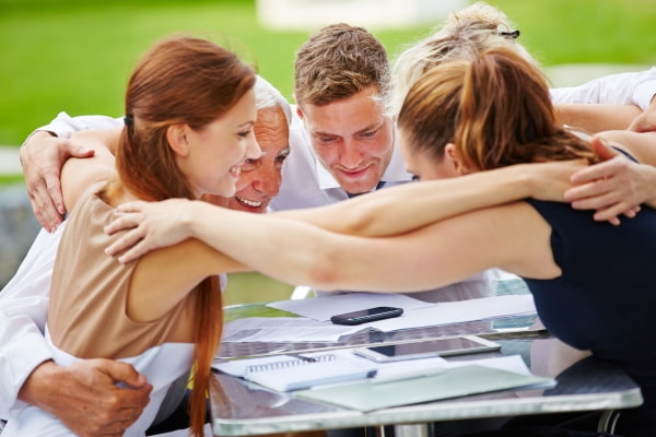 group of people huddling together as partners