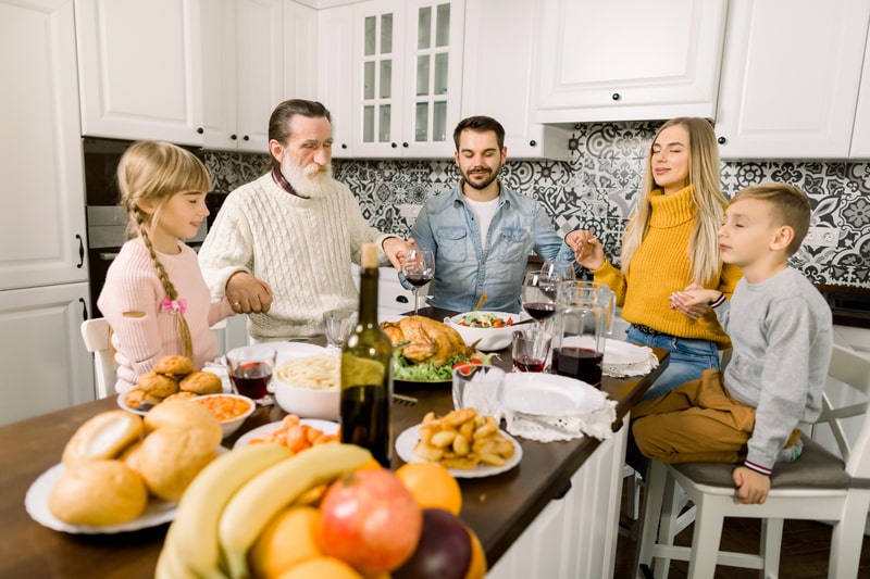 family praying a blessing at dinner