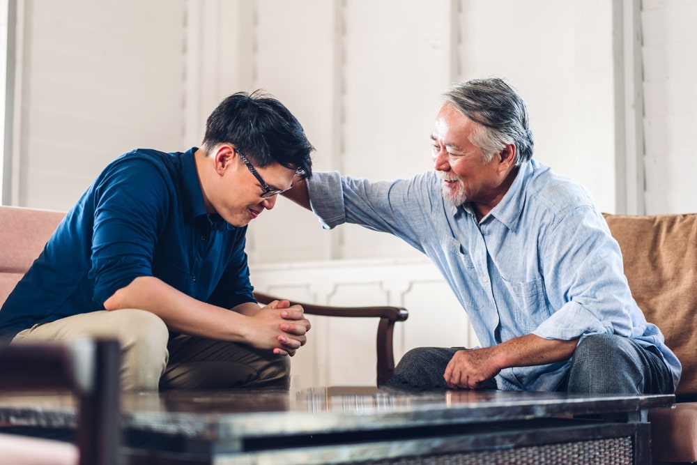 man praying a blessing over his son